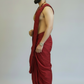 Man wearing a red dhoti against a plain background
