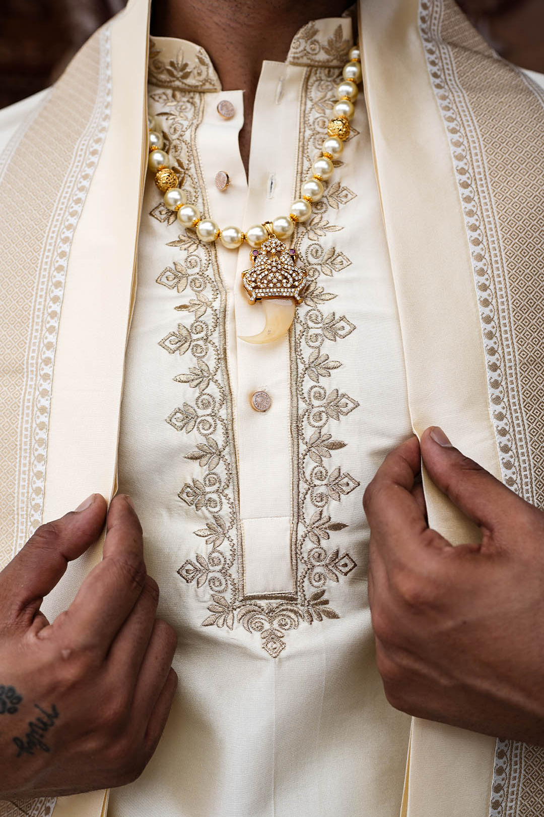 Close-up of a person wearing an embroidered traditional outfit with a necklace.
