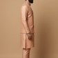 Man wearing a pink traditional outfit against a beige background