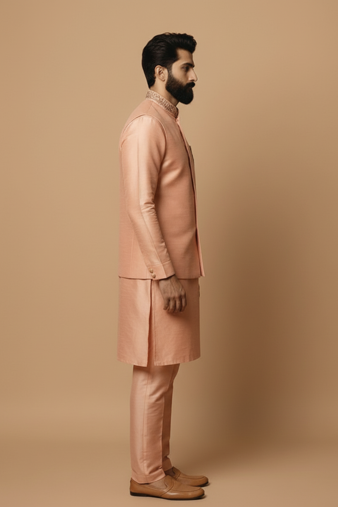 Man wearing a pink traditional outfit against a beige background