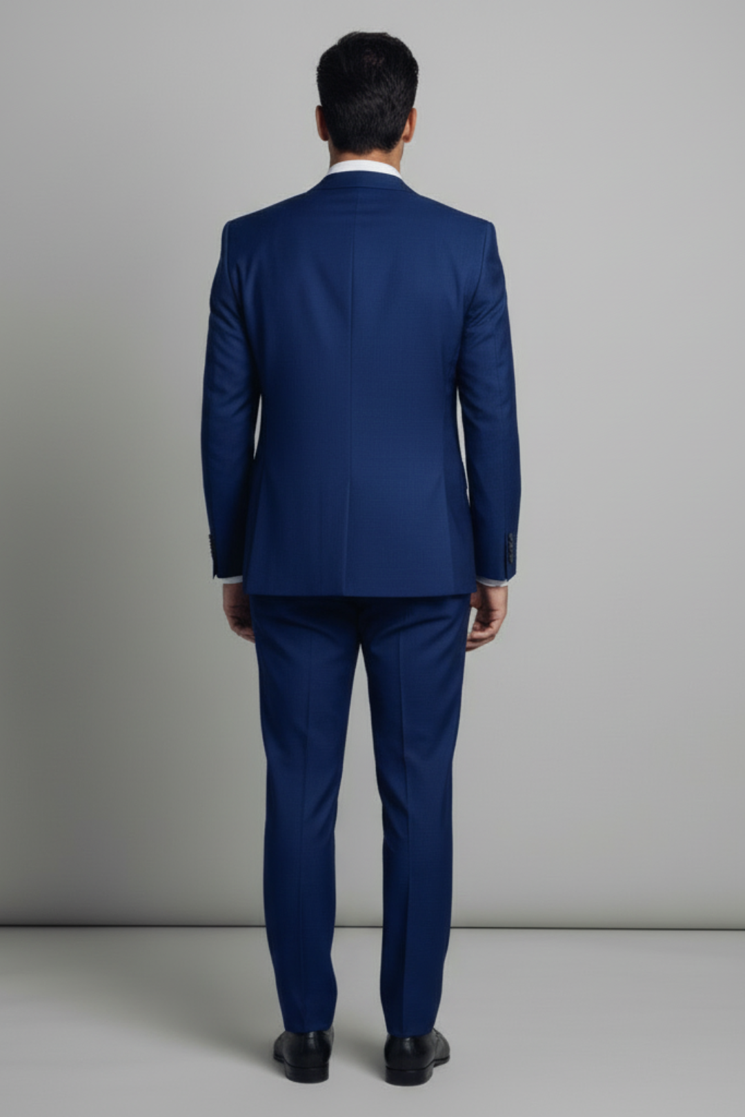 Man wearing a blue suit against a gray background