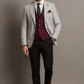 Man wearing a gray suit with a maroon vest and black pants against a plain background