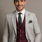 Man wearing a gray suit with a maroon vest and black tie against a neutral background