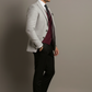 Man wearing a gray suit with a maroon vest against a neutral background
