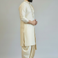 Man wearing a traditional cream kurta with a white dhoti on a plain background