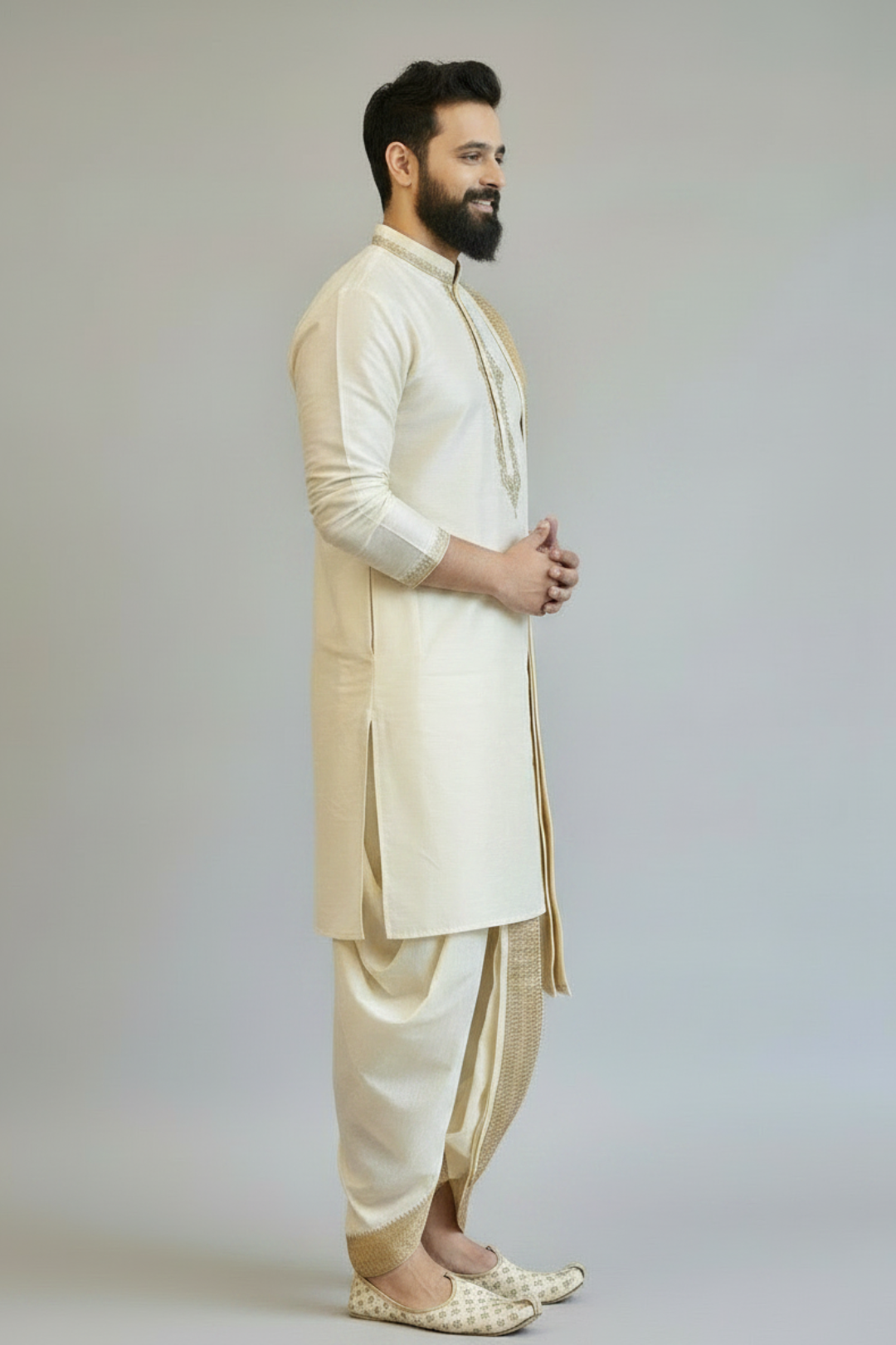 Man wearing a traditional cream kurta with a white dhoti on a plain background