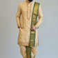 Man wearing a traditional beige kurta with green embroidery on a plain background