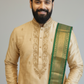 Man wearing a traditional embroidered kurta with a green border on a gray background