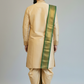 Man wearing a beige traditional outfit with a green border on a plain background