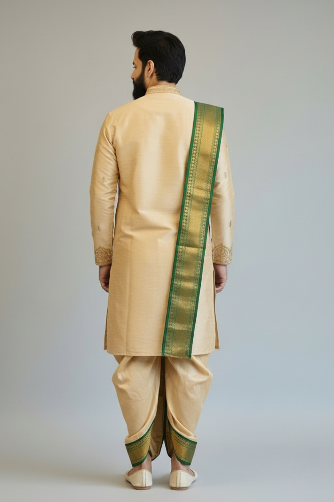 Man wearing a beige traditional outfit with a green border on a plain background