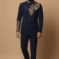 Man wearing a navy blue embroidered suit on a beige background