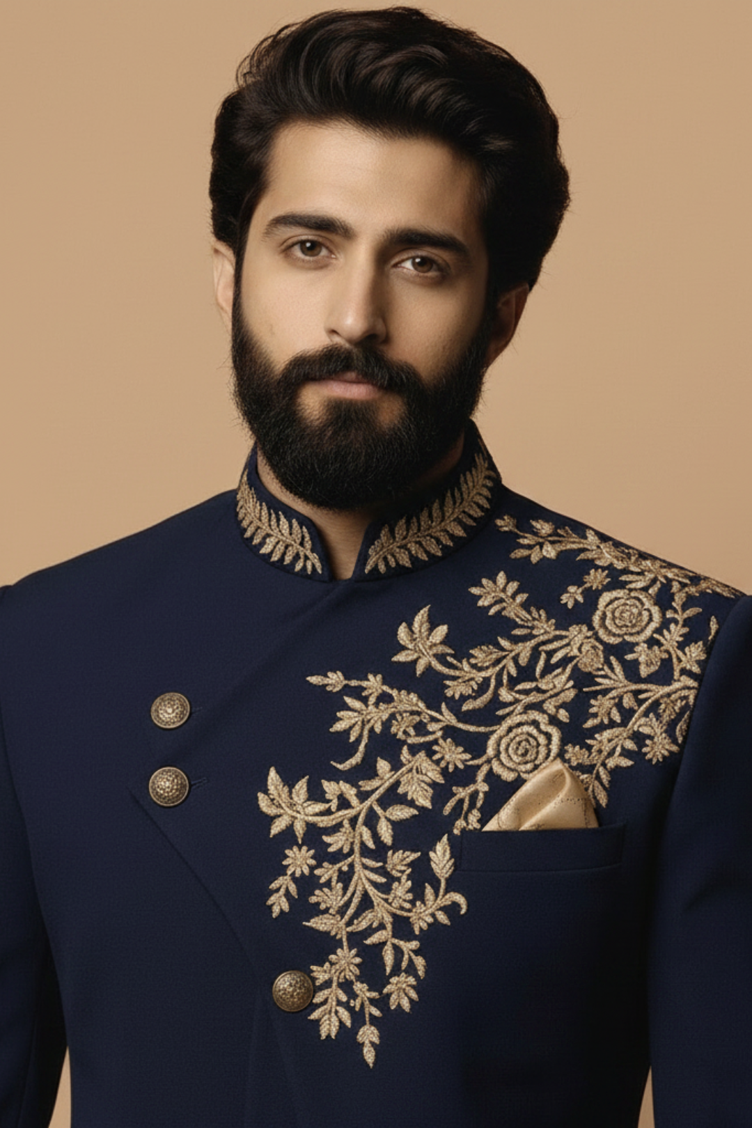Man wearing a navy blue embroidered traditional outfit against a beige background