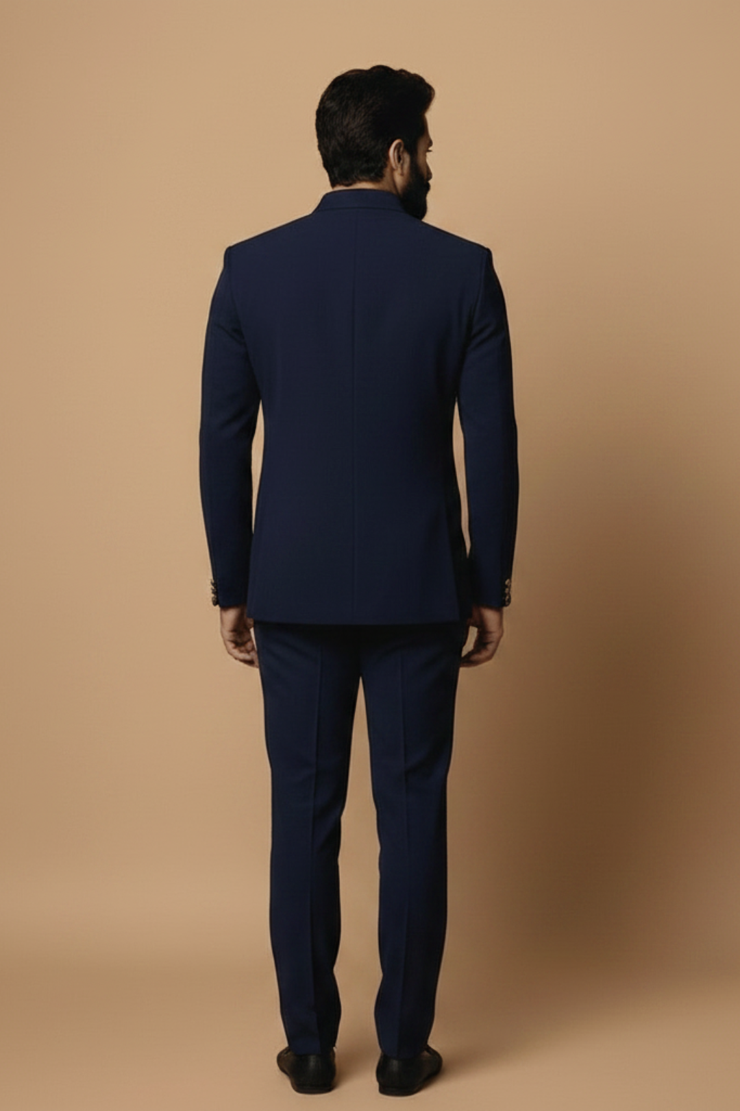 Man wearing a navy blue suit against a beige background
