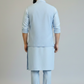 Man wearing a light blue kurta set against a plain background