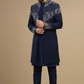 Man wearing a navy blue sherwani with intricate patterns on a beige background