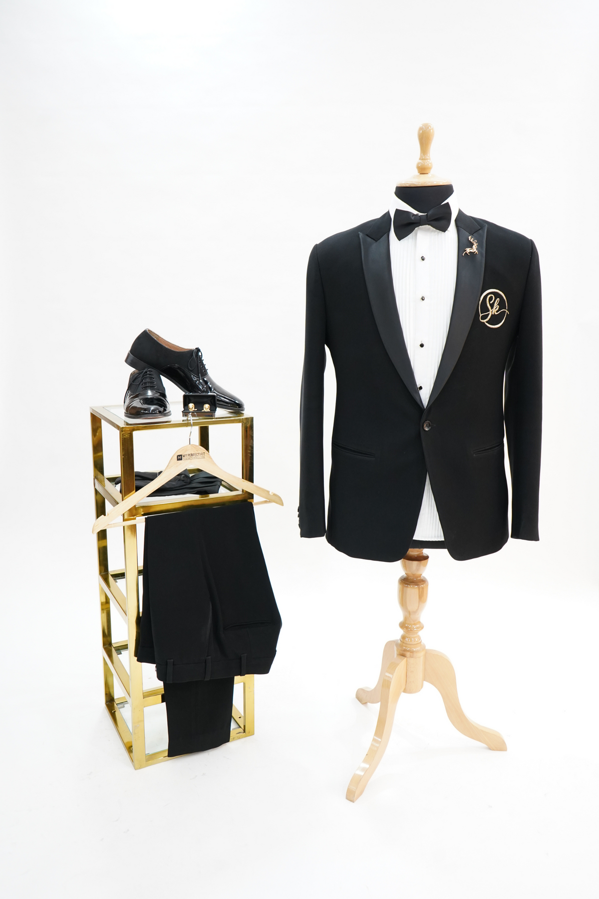 A Black suit with a white shirt and black bow tie on a plain background