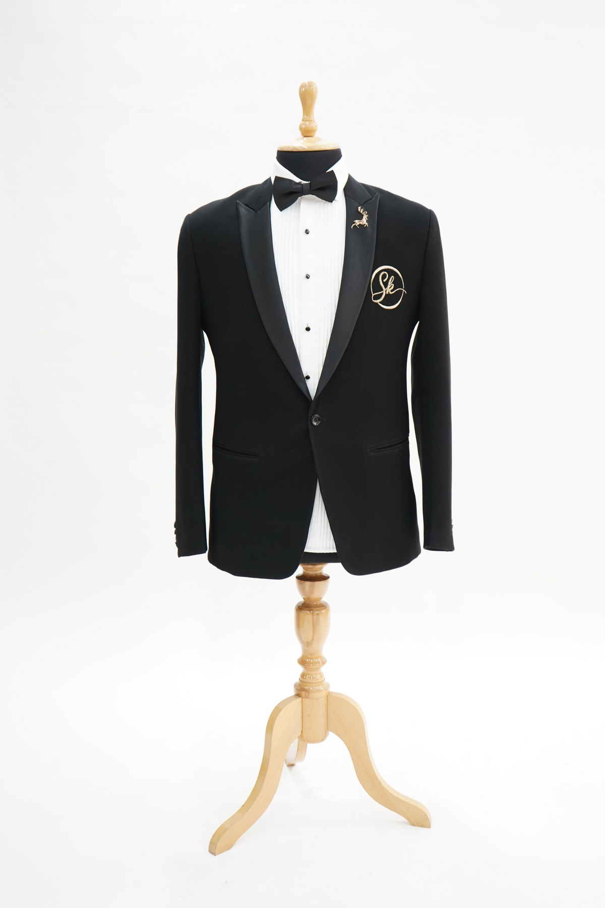 a black suit with a white shirt and black bow tie on a plain background