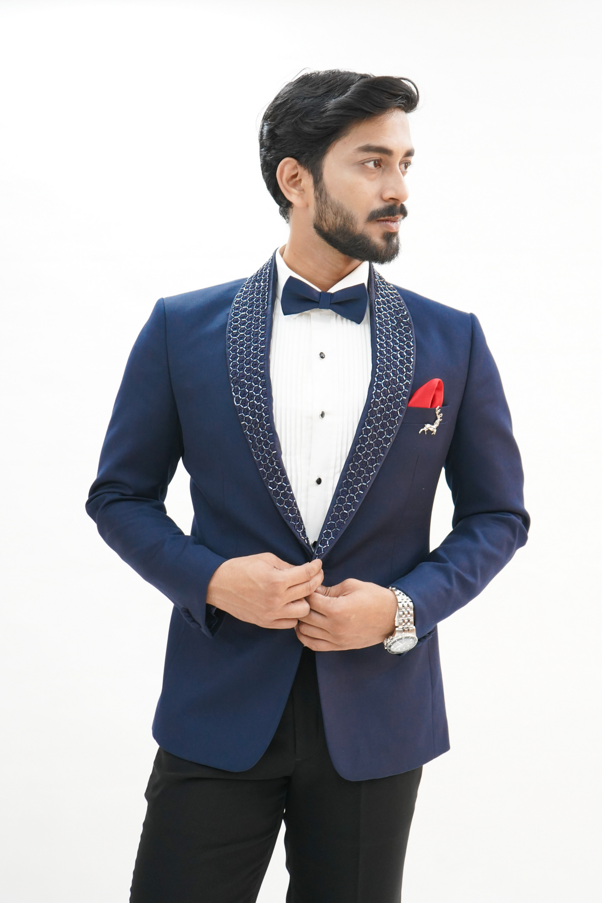  wearing a navy blue wool crepe 2-piece tuxedo with a detachable lapel, consisting of a jacket and trousers, accessorized with a bow tie and a handkerchief.