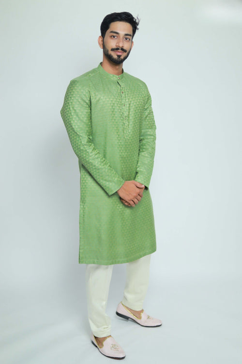 Man wearing a green kurta with white pants on a white background