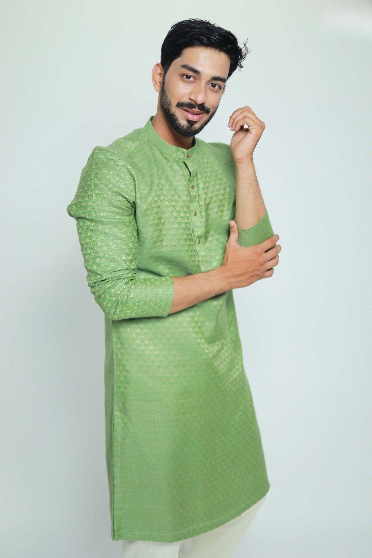 Man wearing a green kurta against a white background