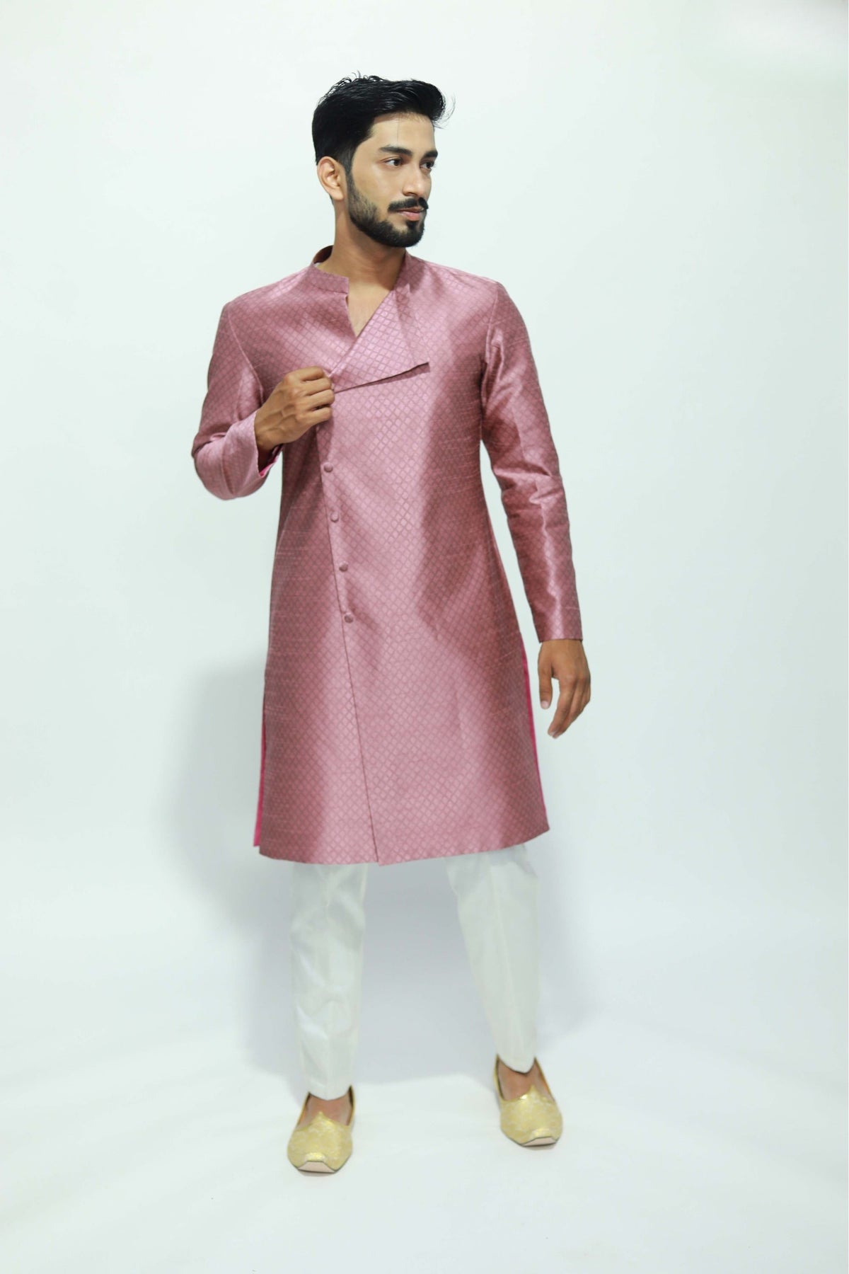 Man wearing a pink kurta with white pants on a white background